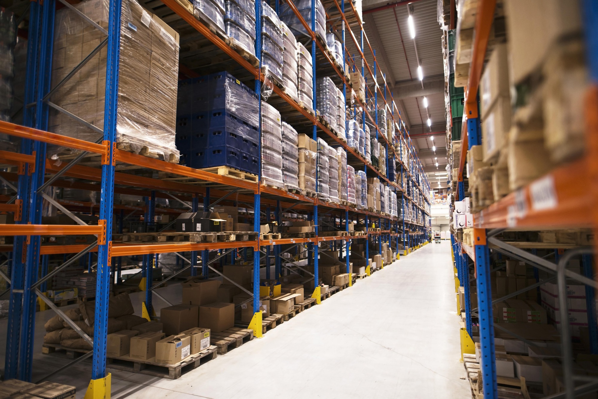 interior large distribution warehouse with shelves stacked with min